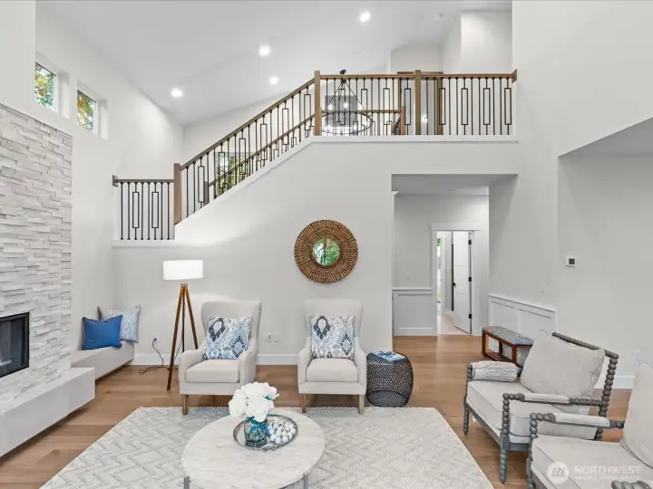 Bright and spacious Great Room featuring a grand open staircase and impressive high ceilings that elevate the home's open-concept design.
