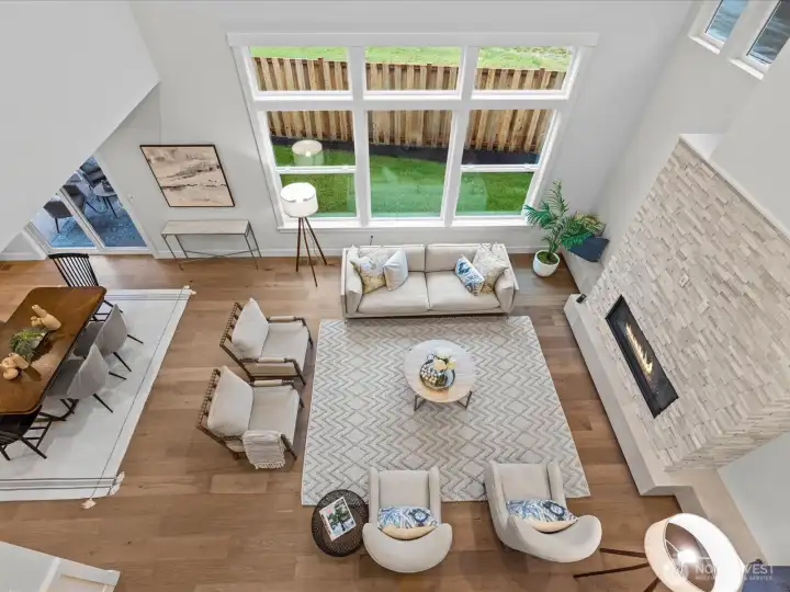 Dramatic view looking down from the upper level, highlighting the soaring ceilings, impressive wall of windows, and open-concept layout.