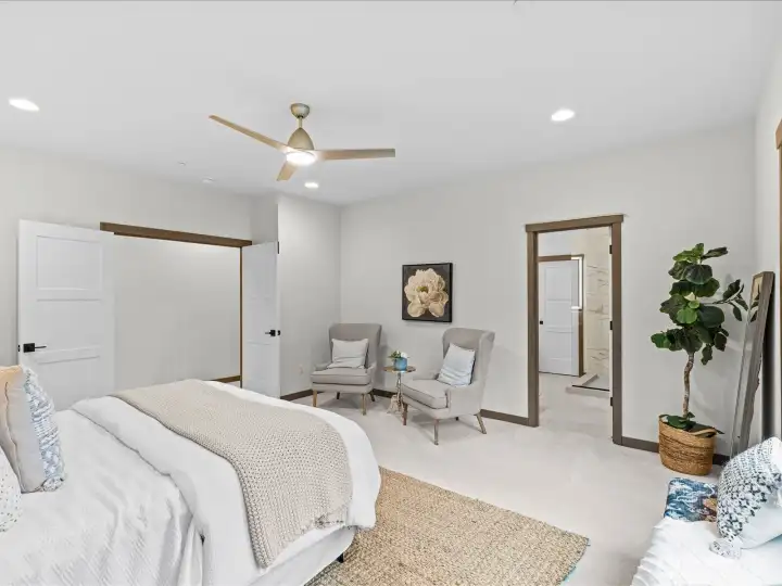 Inviting primary bedroom suite looking towards the private bath, highlighting the room's generous layout and beautiful natural light.