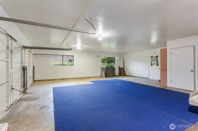 Oversized 3 car garage with storage, door on right.  Door to left leads to backyard and covered patio