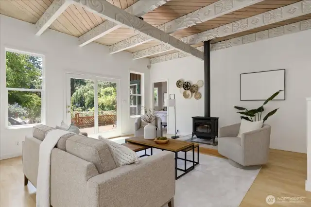 SPACIOUS LIVING ROOM WITH PROPANE STOVE AND FRENCH DOORS LEADING TO THE DECK