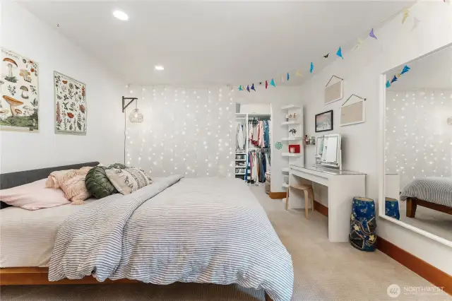 First extra-large lower-level bedroom featuring a walk-in closet and custom built-ins—perfect for guests or multi-generational living.