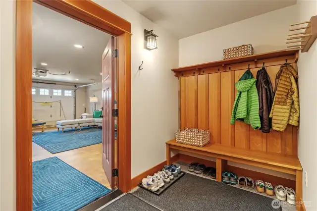 Lower-level garage entrance features built-in bench seating, coat hooks, and shoe storage—combining comfort and functionality as you enter the home.
