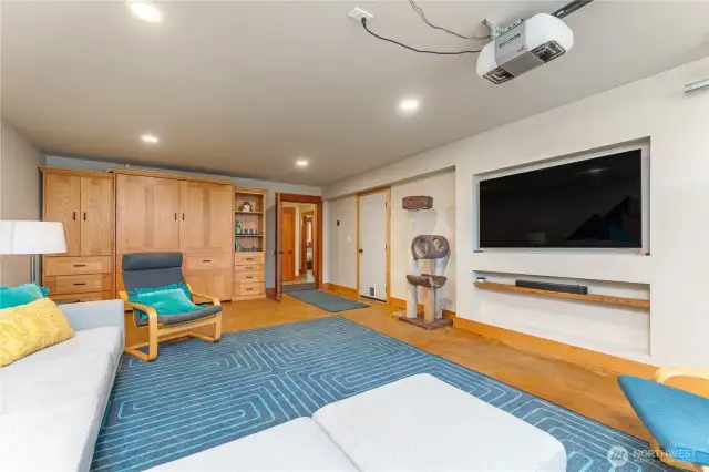 The first garage bay has been converted into a versatile bonus room complete with a Murphy bed and entertainment area—perfect for guests or flexible living space.