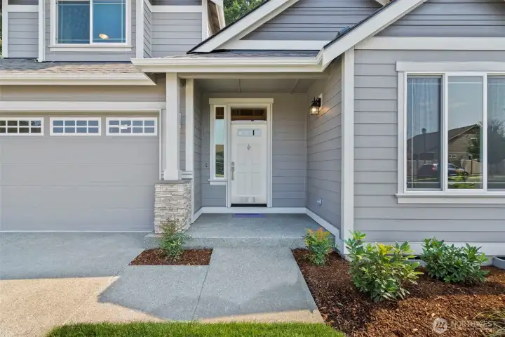 Welcoming entry with stone panels in porch and garage.