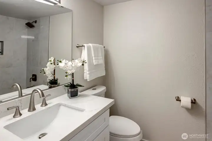 Full bath with tiled tub shower combo.