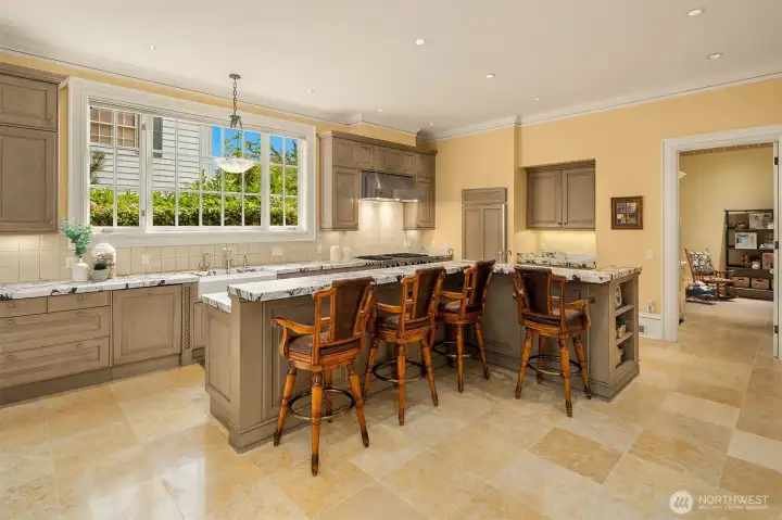 Gourmet kitchen with L-shaped island offering generous bar seating, gorgeous Calacatta Vaglia Rosato marble countertops, and timeless custom cabinetry by Downsview Kitchens.