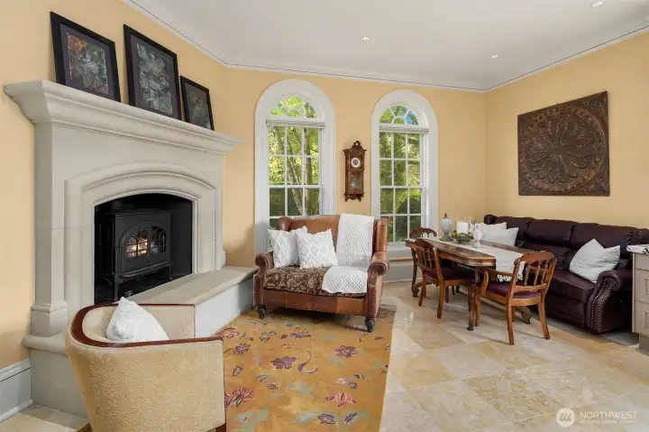 Wonderful breakfast area and fireside sitting area with custom limestone gas fireplace. The tall classic windows overlook the north gardens.