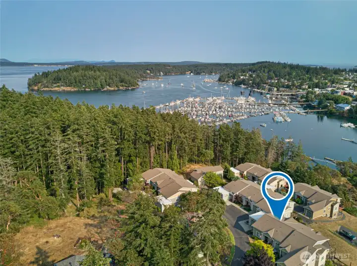 This sweeping aerial view highlights the condo's elevated position with a charming peek of Friday Harbor's inner bay. The serene setting offers a sense of peaceful seclusion while keeping you just moments from the lively waterfront community of Friday Harbor.