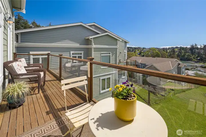 Spacious south facing private deck off the living room with unobstructed views of the bay of Friday Harbor, creating an ideal outdoor living space.