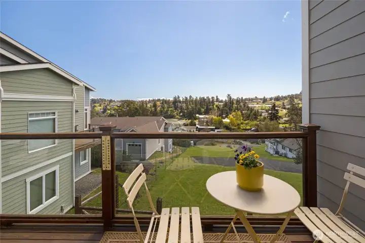 Sunny deck off the living room offers sweeping views over lush green lawns and the Friday Harbor townscape, and a glimpse of the bay, perfect for morning coffee or evening relaxation.