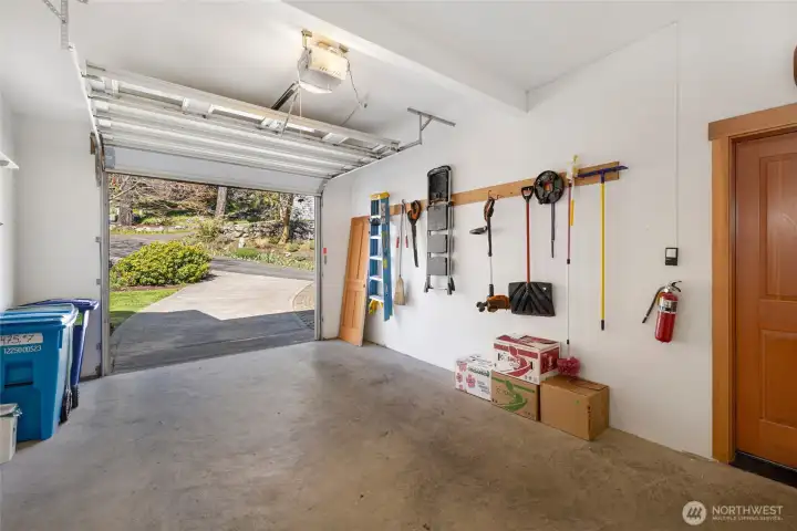 The spacious single-car garage offers a clean concrete floor, an organized pegboard tool wall, and ample room for both parking and storage. A convenient interior door provides direct access to the laundry room and condo's living areas.