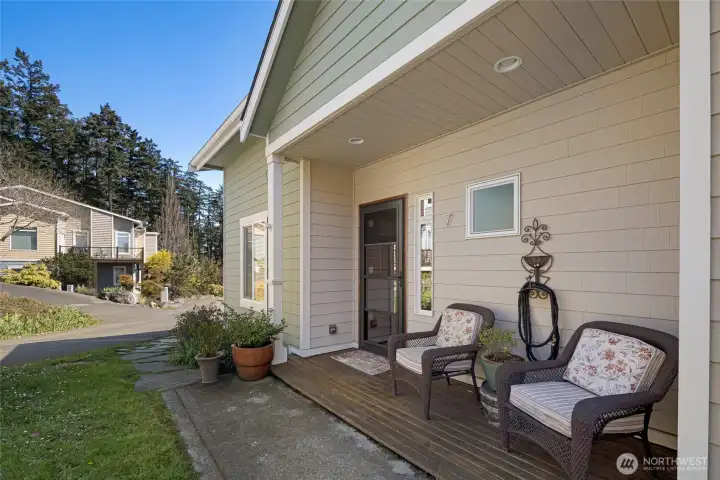 The welcoming covered front porch features recessed lighting, and a stylish dark-frame entry door, offering a peaceful spot to enjoy the San Juan Island surroundings. Lush landscaping and a manicured lawn enhance the condo's exceptional curb appeal.