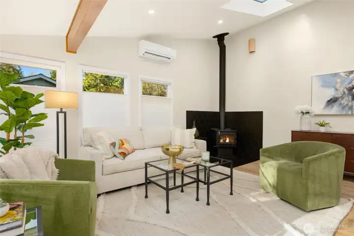 Enter into an open concept great room filled with natural light featuring exposed beams, cozy woodstove, vaulted ceilings and skylights.