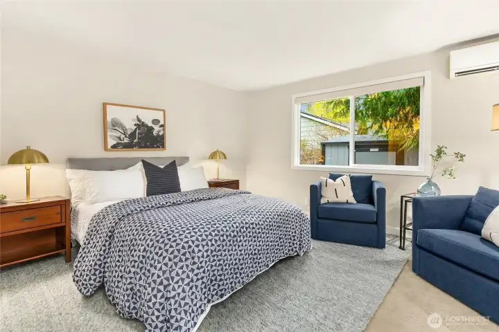 The main floor primary bedroom is spacious and bright