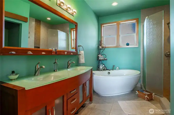 Primary bath, with heated tile floors, soaking tub, glass shower and double vanity.