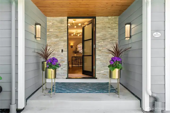 A covered entry with warm wood ceilings, modern lighting, and clean architectural lines creates a welcoming first impression the moment you arrive.