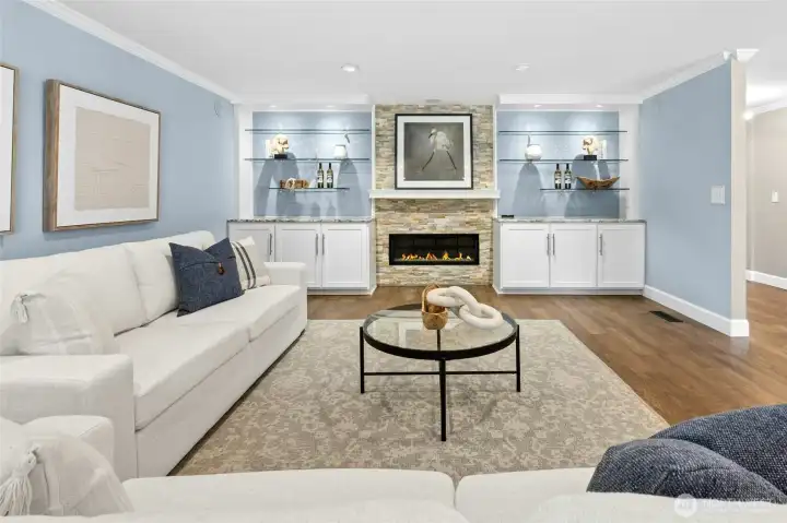 The living room blends warmth and elegance with crown molding, rich wood flooring, and a gas fireplace flanked by handy built-ins. Want to make this your media room? TV mount and built-in surround sound are already installed.