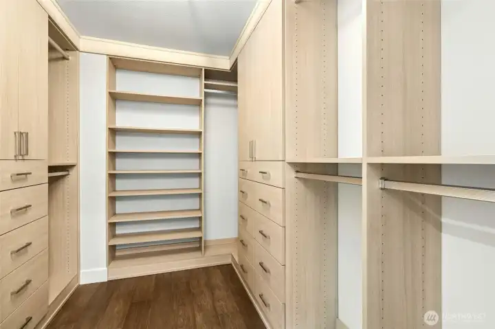 The custom walk-in closet is thoughtfully designed with built-in shelving, drawers, and hanging space to keep everything organized and within reach.