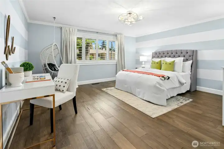 This spacious main floor bedroom feels bright and welcoming, with plantation shutters and custom decor. Clean finishes and an airy layout create a comfortable setting for guests, work, or everyday living.
