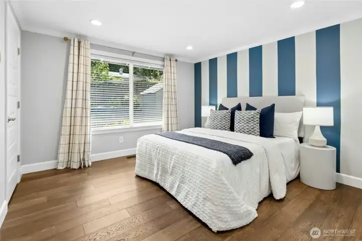 This main-floor bedroom offers clean, modern finishes, a walk-in closet, and views of the private side yard and hot tub retreat just outside.