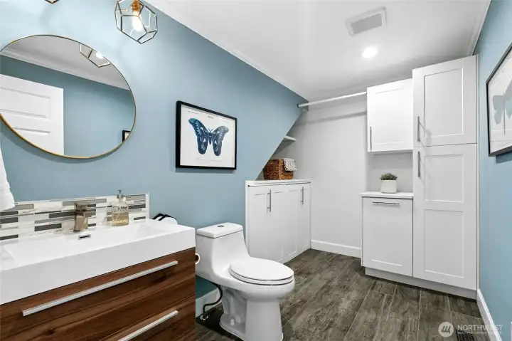The main floor laundry and half bath combine style and function with modern finishes, abundant storage, and a thoughtfully designed layout.  Custom cabinet doors cleverly conceal the washer and dryer when not in use, keeping the space polished and streamlined.