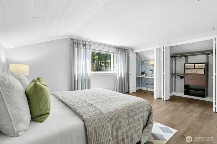 This upper-level bedroom offers a flexible and thoughtfully designed layout with a hideaway study nook on one side and organized closet space on the other.  The tongue-and-groove ceiling adds warmth and character, offering a subtle nod to the history and original charm of the home.