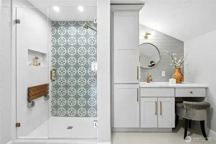 The beautifully designed upper level 3/4 bath makes exceptional use of the space with a walk-in shower, custom vanity, and striking patterned tile accents.