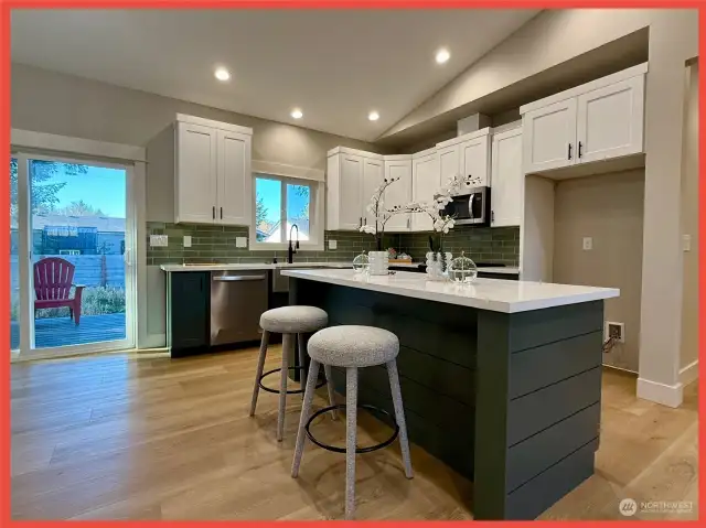 The kitchen features gorgeous cabinetry, stainless steel appliances, Quartz slab countertops, tiled backsplash and island/breakfast bar.