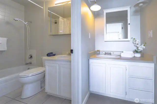 Dual vanities and a split layout offer privacy and functionality—an ideal design for seamless mornings and evening wind-downs.