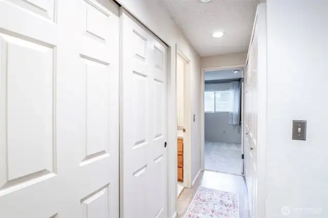 Hallway features two large closets, one for storage, the other holds the W/D as well as additional storage shelving.