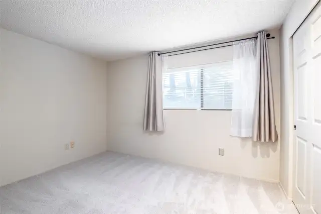 Second bedroom. Faces the front. Featuring fresh new carpet.