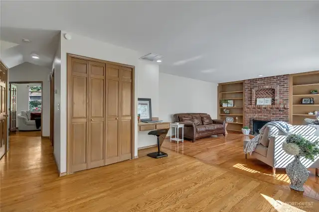 The kitchen flows seamlessly into the adjacent gathering room, featuring a built-in desk perfect for managing tasks, alongside a convenient pantry for extra storage. It’s a practical and stylish space for everyday living.