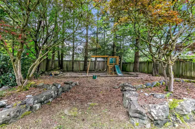 The fully fenced backyard features a dedicated children's play area, providing a safe and fun space for kids to enjoy.