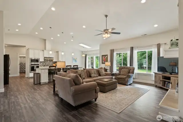 From the living area in the great room looking towards the kitchen. Take note of the skylight.  Big windows and skylight add to all of the natural light!