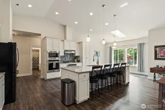 Fantastic kitchen with granite eating bar and counters, white cabinets, and glass tile back splash. Well detailed!