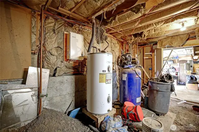 Utility space in the crawlspace is just off the garage/current wood shop.  The tankless water heater has not been connected.  There is natural gas available but not connected to the home.