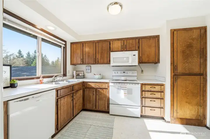 Bright kitchen accented by a large window and abundant natural light.
