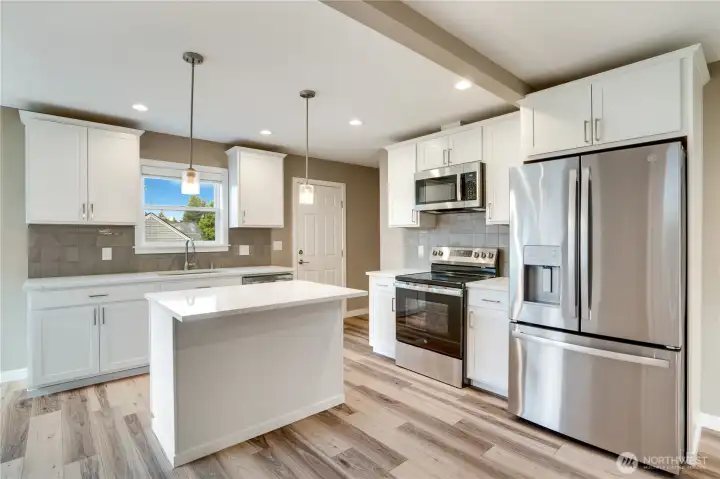 You can’t go wrong with this investment—everything here is brand new- cabinets, appliances, lighting, counters and stylish tile backsplash. Don’t miss the convenient side door and the staircase to the basement located just behind the stove, offering easy access and smart functionality.