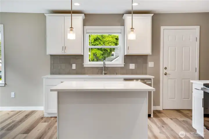 An eat-in island with storage, a new dishwasher, and an oversized sink give this kitchen a fresh, modern feel that really shines.