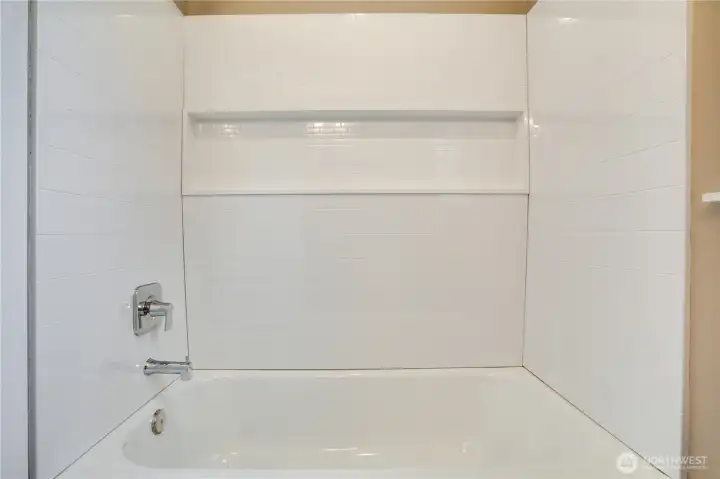 The new tub surround and modern fixtures offer a sleek finish and low-maintenance durability.