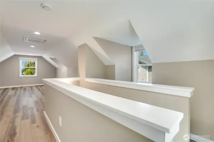 This open upstairs bedroom, which also works beautifully as a separate office, carries the same LVP flooring, refreshed millwork, bright windows, and a ceiling-mounted heat pump for year-round comfort.
