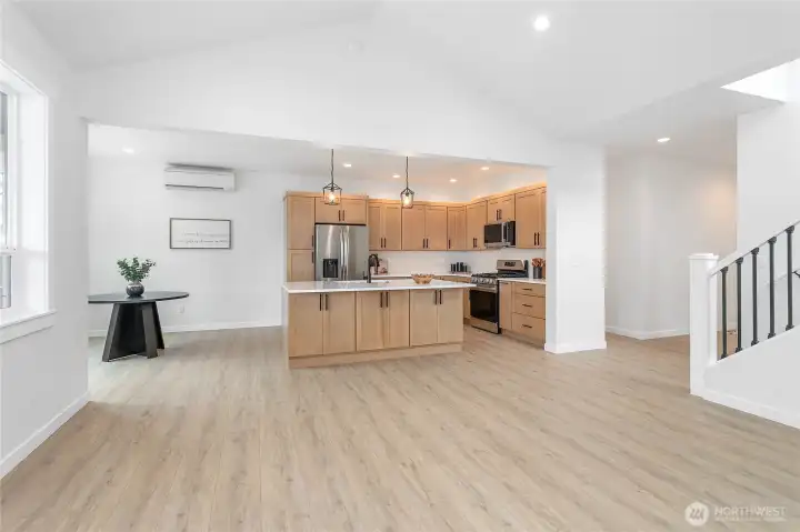 The opening on the far right hand side it the front entryway.  The opening to the right hand side of the kitchen leads to the master bedroom, utility room and garage.
