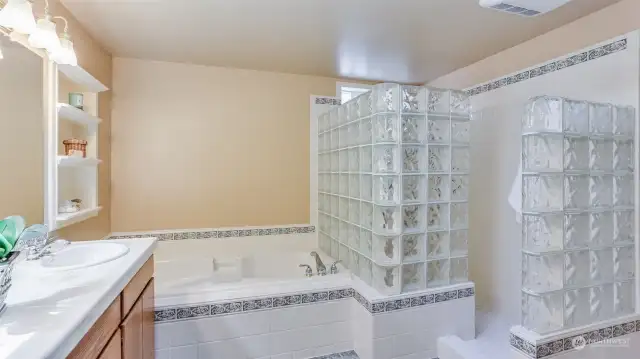 Enjoy the extra large tile surround walk-in shower with glass block in this primary bathroom.