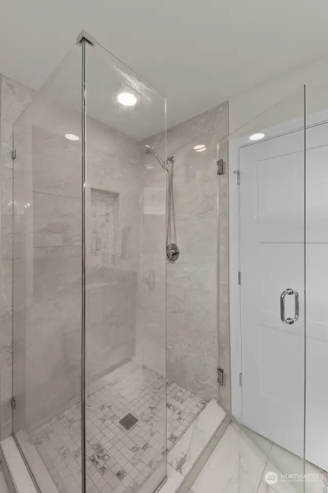 Enjoy the luxury of a walk-in glass-enclosed shower, offering a modern and sleek design with elegant tile work.