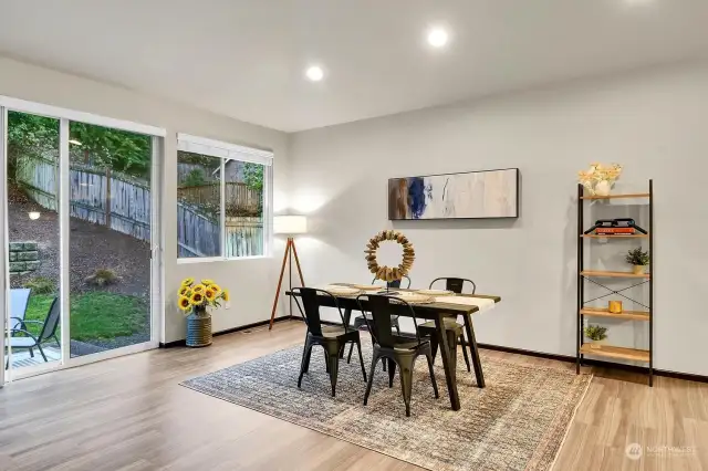 The dining room benefits from ample natural light, provided by several windows and the sliding glass door.