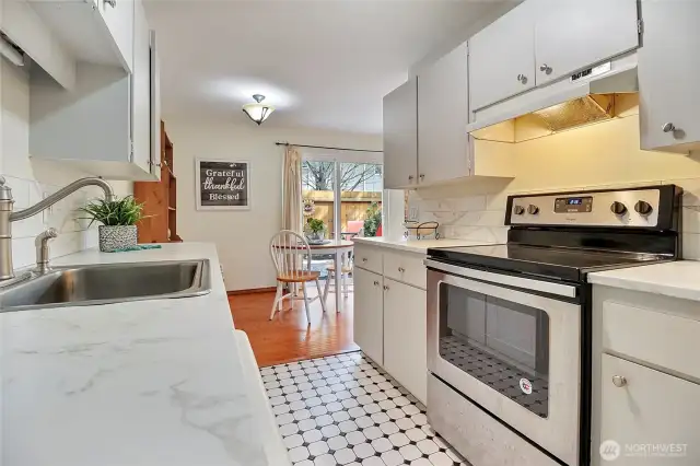 Fresh kitchen with convenient breakfast eating area and access to laundry.