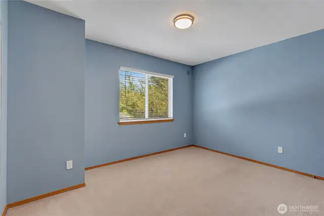 Calming blue walls in this secondary bedroom make it ideal for a home office, guest room, or creative space.