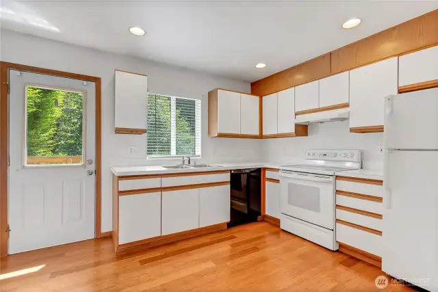 Bright and functional kitchen with updated floors and direct access to the private deck—perfect for summer dinners or coffee breaks.