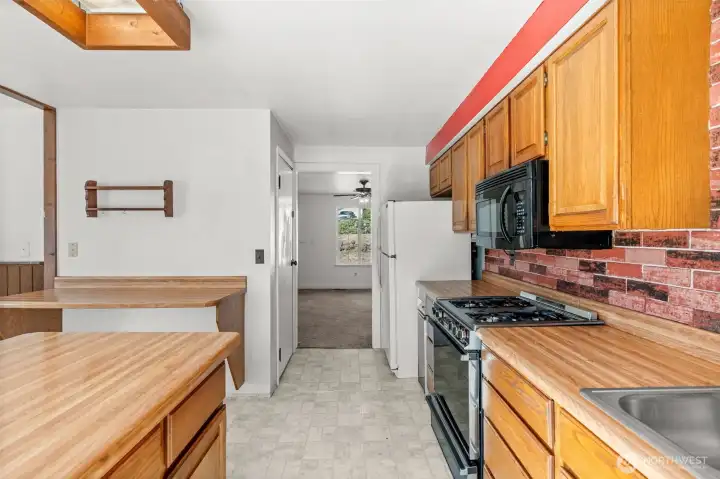 The kitchen showcases a central island with direct access to the covered deck, creating an ideal space for entertaining in any season.